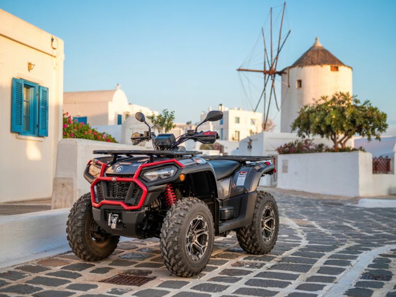 Rental ATV from Paros Moto parked in a narrow alley in Paros with the iconic Parikia windmill visible in the background
